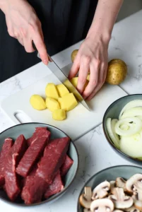 Slicing russet potatoes thinly for potato beef stroganoff recipe