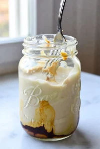 Whisking milk, Greek yogurt, and melted cookie butter in a wide-mouth mason jar