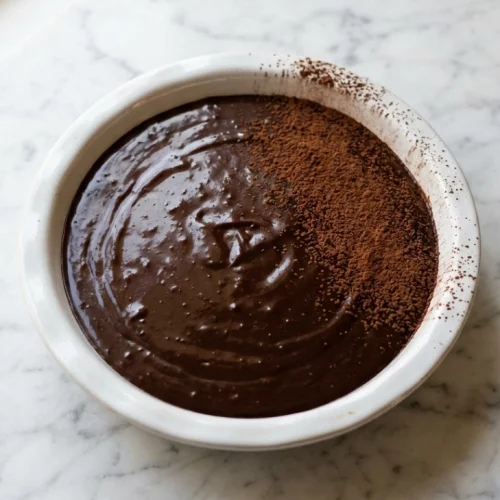 Chocolate ganache dusted with cocoa powder in white dish