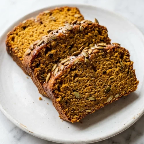 Three slices of spiced pumpkin bread fanned on white dish